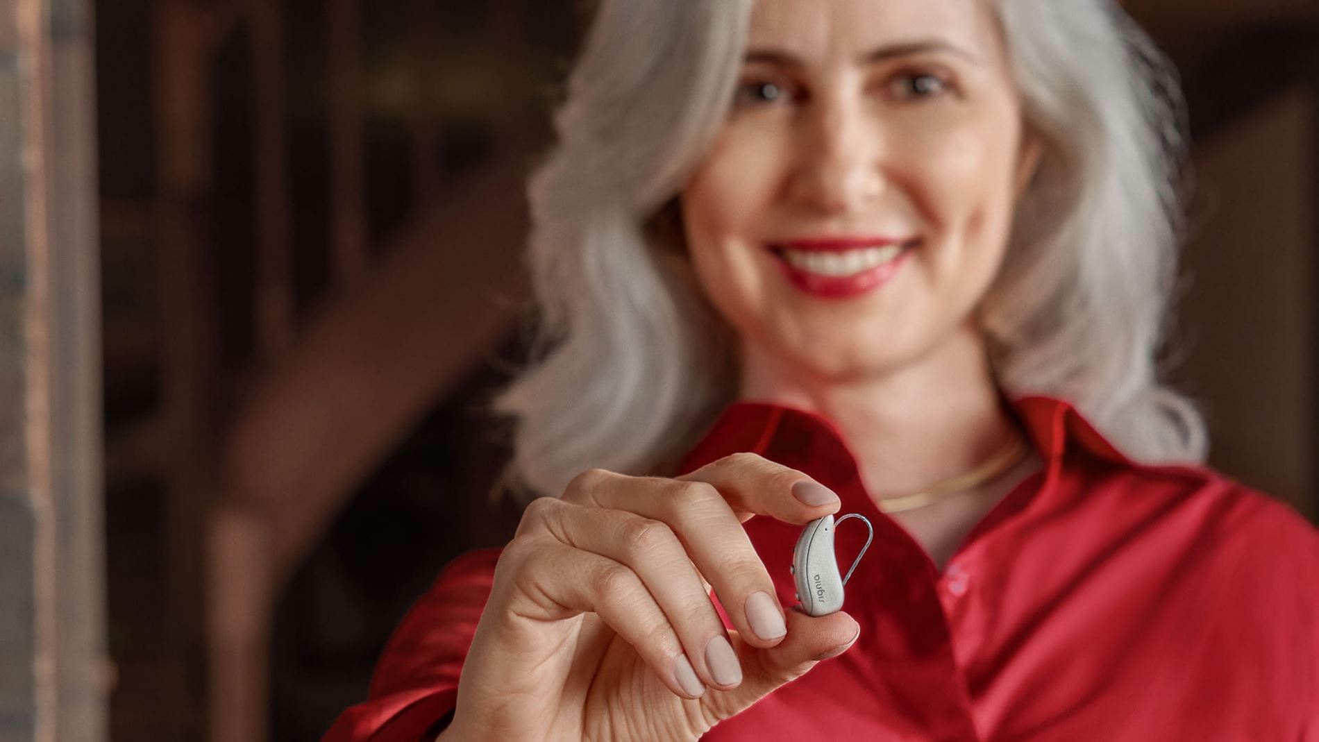 Patient holding a Signia hearing aid